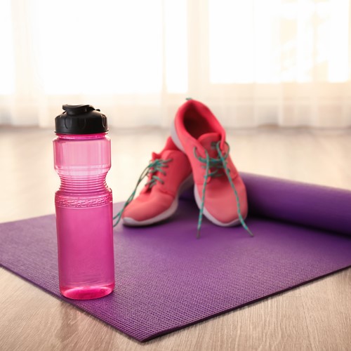 trainers and water bottle on a floor mat ready for a workout
