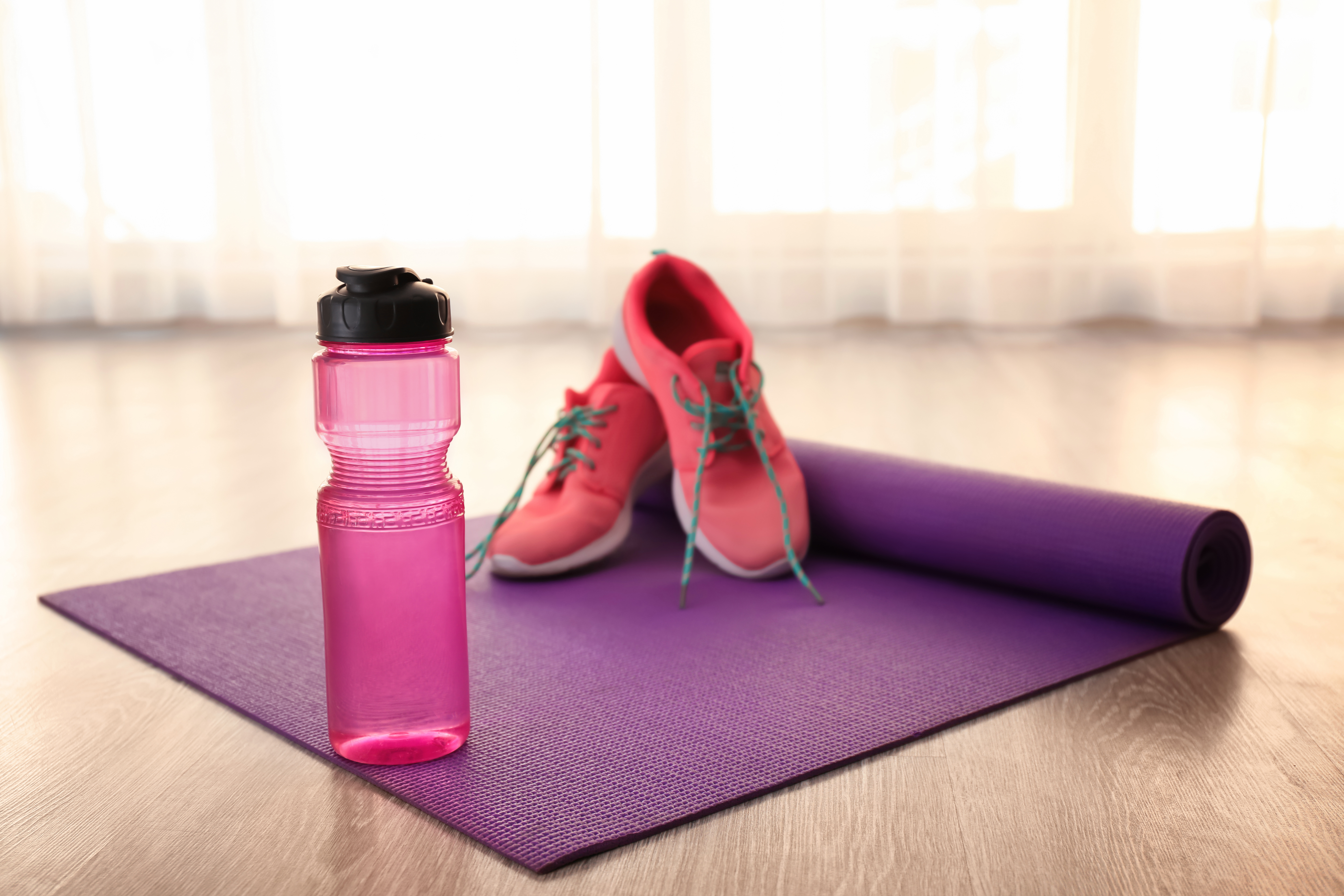 trainers and water bottle on a floor mat ready for a workout