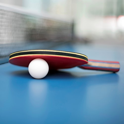 Table tennis bat and ball on a table tennis table